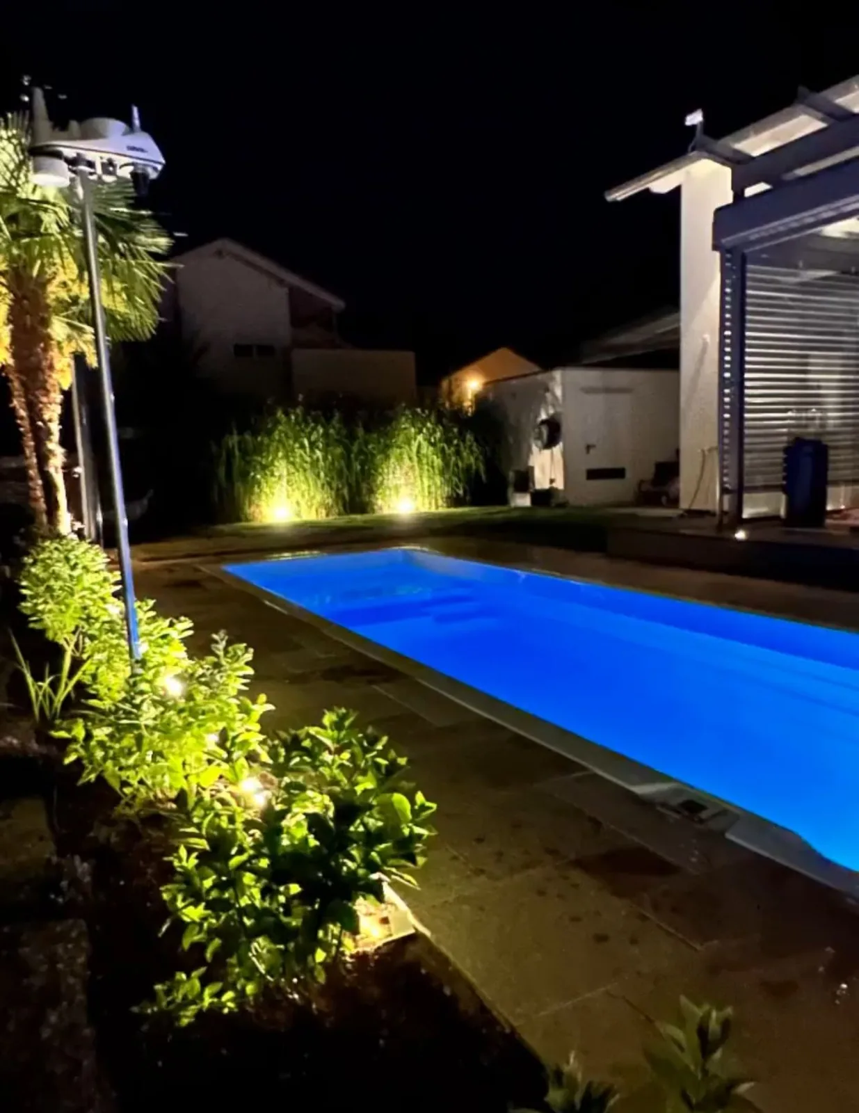 INFINITAS swim spa fully inground with lighting at night