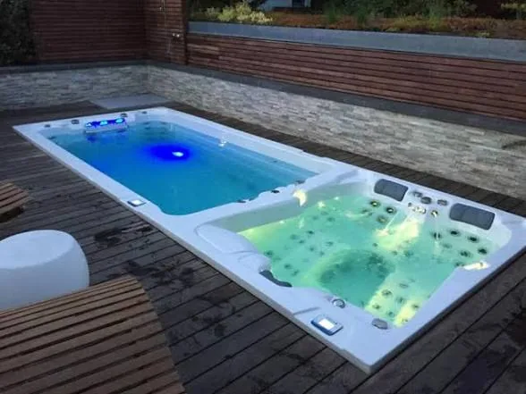 Combinazione di swim spa e minipiscina INFINITAS in un deck in legno di notte